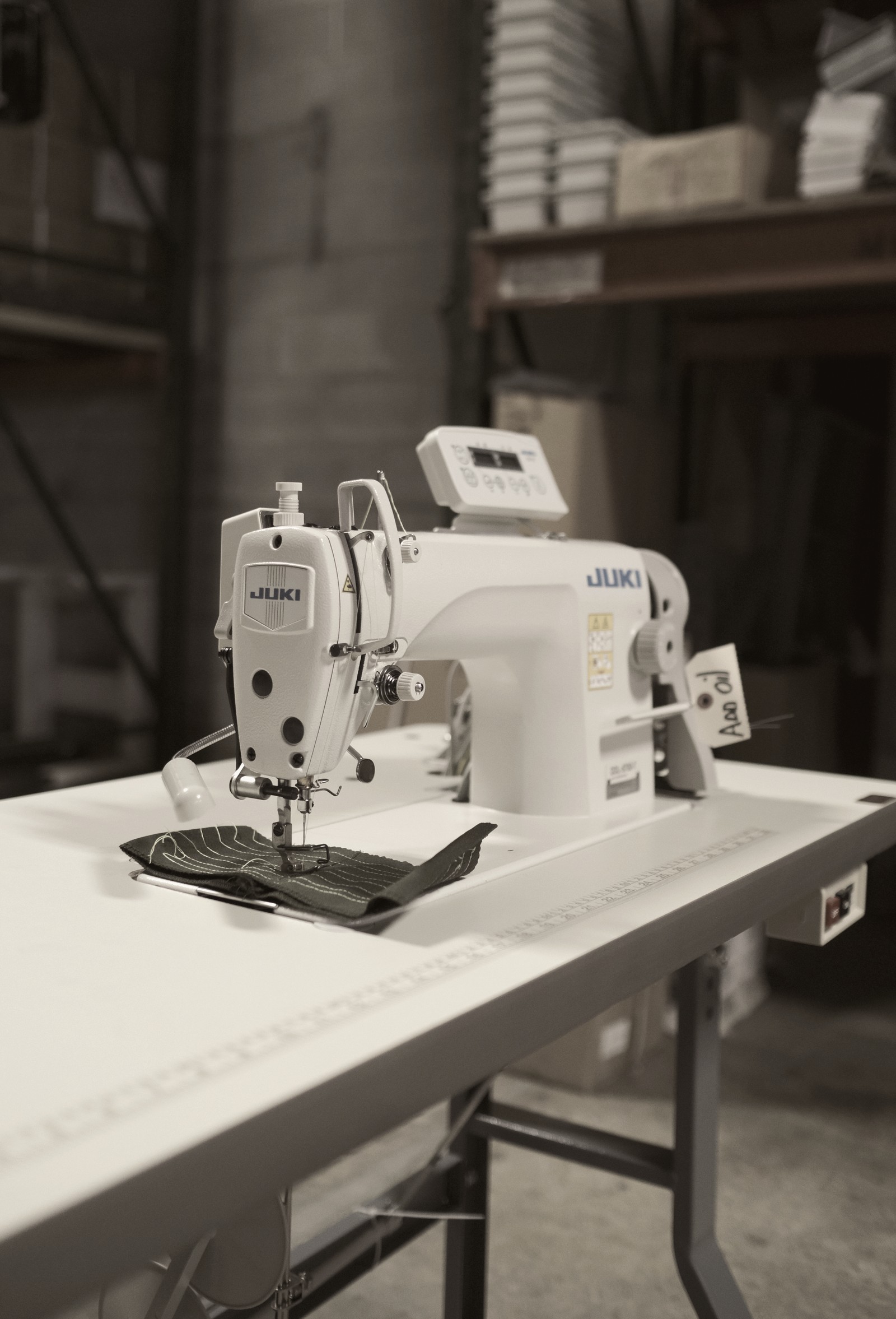 JUKI industrial sewing machine mid-stitch on a production line at Thread Works Studios